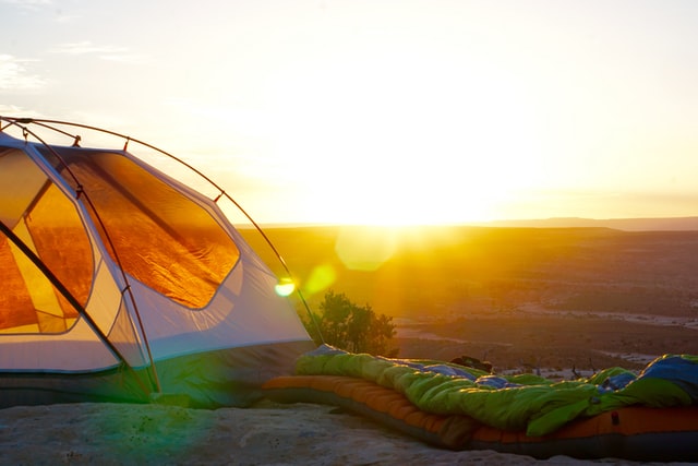 Sunlight hitting an empty tent placed on a high hill