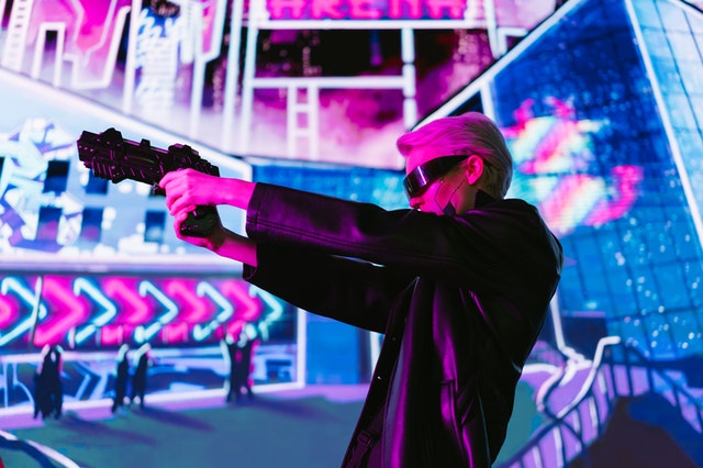 A person shooting in a digital setting with neon lights.