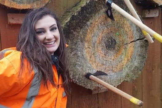 Adventurous date ideas, woman with axe throwing target.
