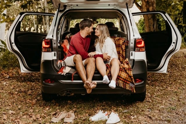 Valentine's day date ideas; couple sitting in the back of a car, enjoying their time together