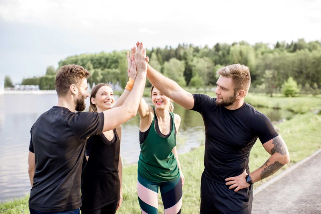 sports that make you stronger, a group of four high fiving each other