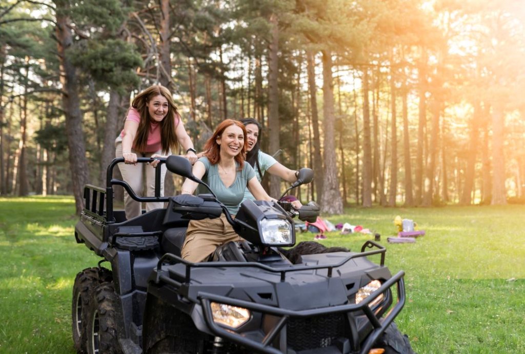 mothers day out ideas, mother with her daughters on a quad bike in nature