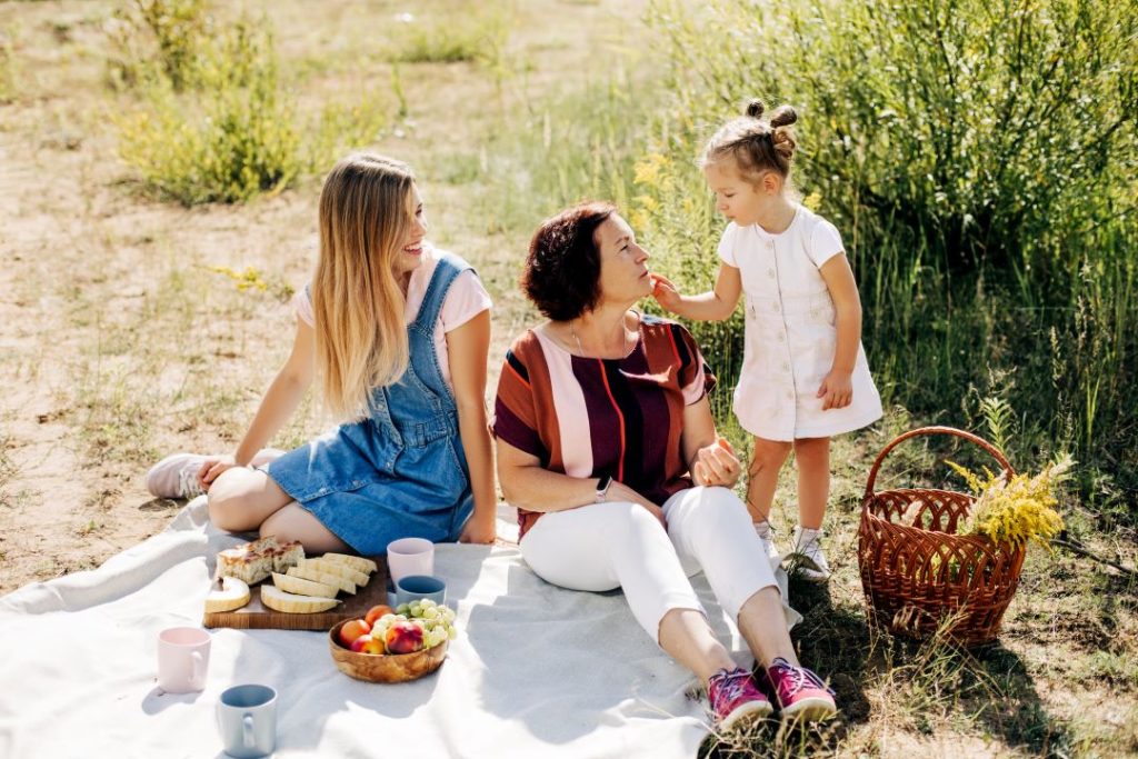 mothers day trip ideas, a mother having a picnic in nature with her daughters