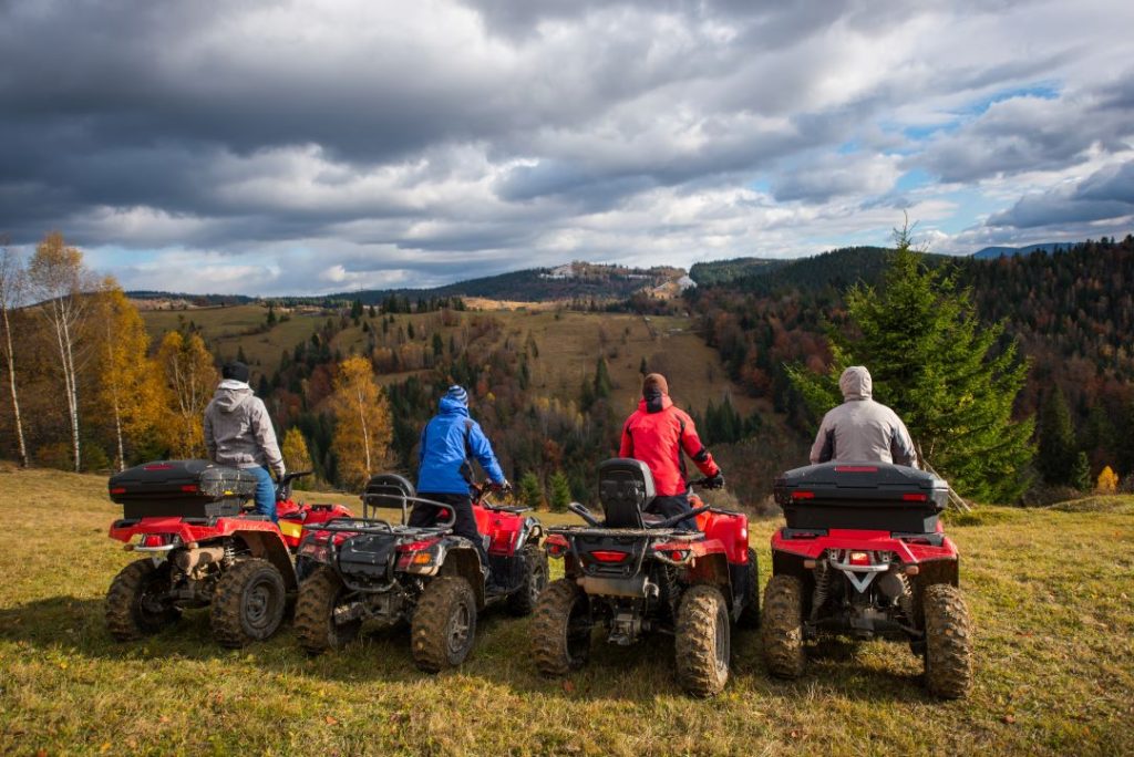 stag do activities, rear view of 4 men at quad bikes prepared to go down a hill