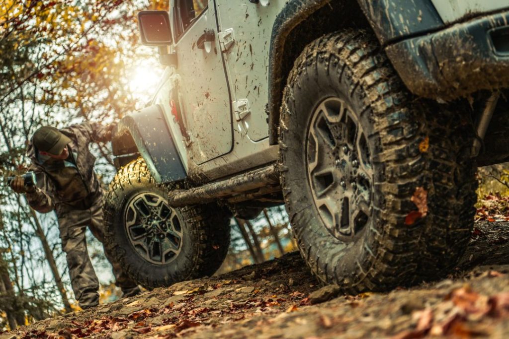off-road driving confidence, person checking the suspension of an off-road SUV vehicle
