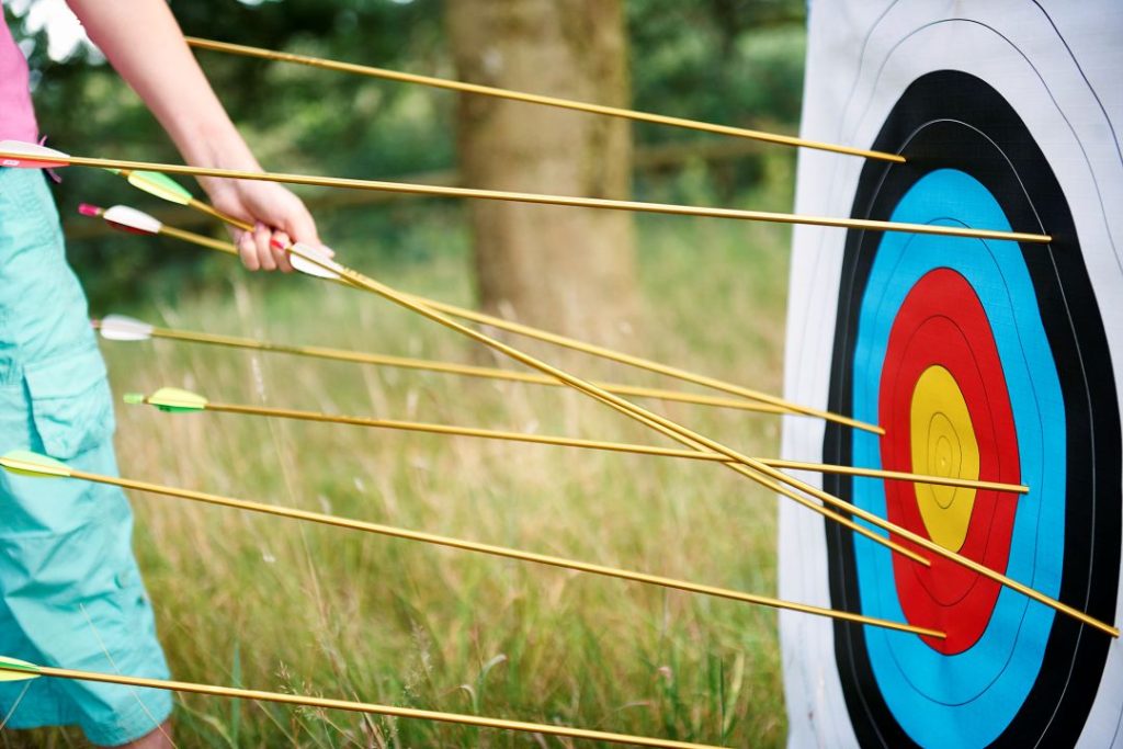 blindfolded archery and sports psychology, a person retrieving arrows from a target