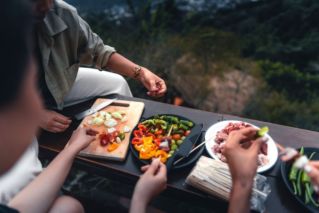 corporate day out itinerary sample for team of 20–50, close-up shot of a barbecue and pan-roasted meat on a mountain
