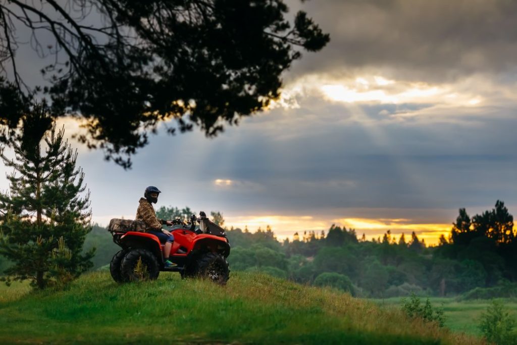 quad biking vs go-karting, a person on a quad bike in the nature during sunset
