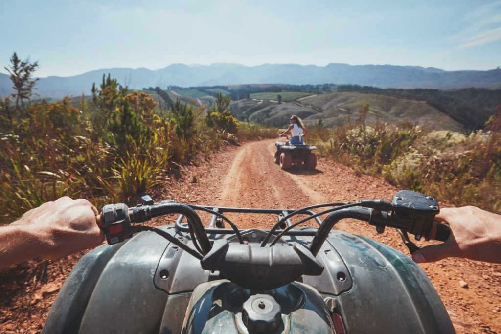 quad biking vs go karting UK, first person view of a person driving a quad bike through muddy terrain