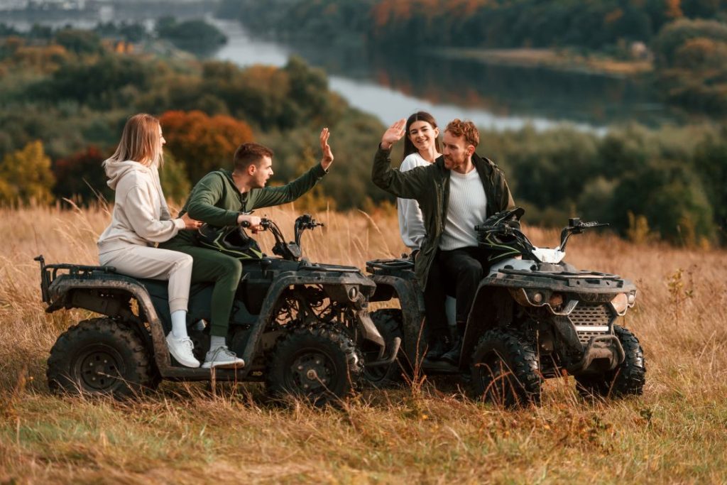 how ziplining compares to off-road driving, a bunch of friends high-fiving on a quad bike and having fun
