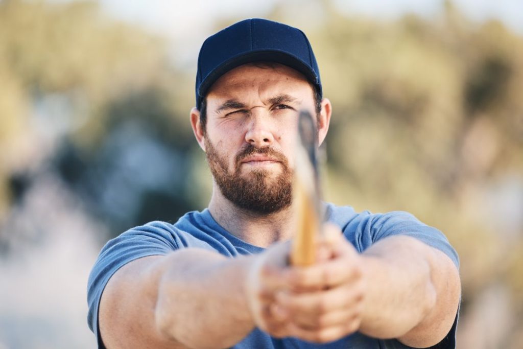 what to expect at an axe throwing stag do, a man focusing his aim as he prepares to throw an axe