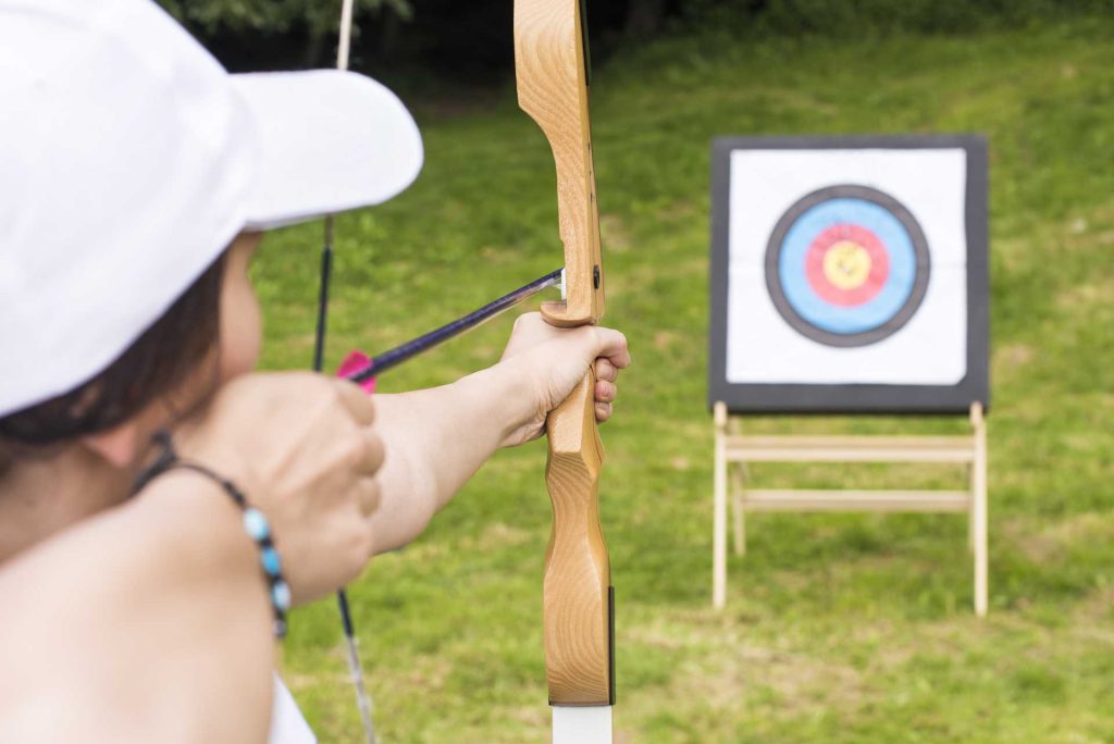 is archery or clay pigeon shooting better, A female archery participant aiming for the target