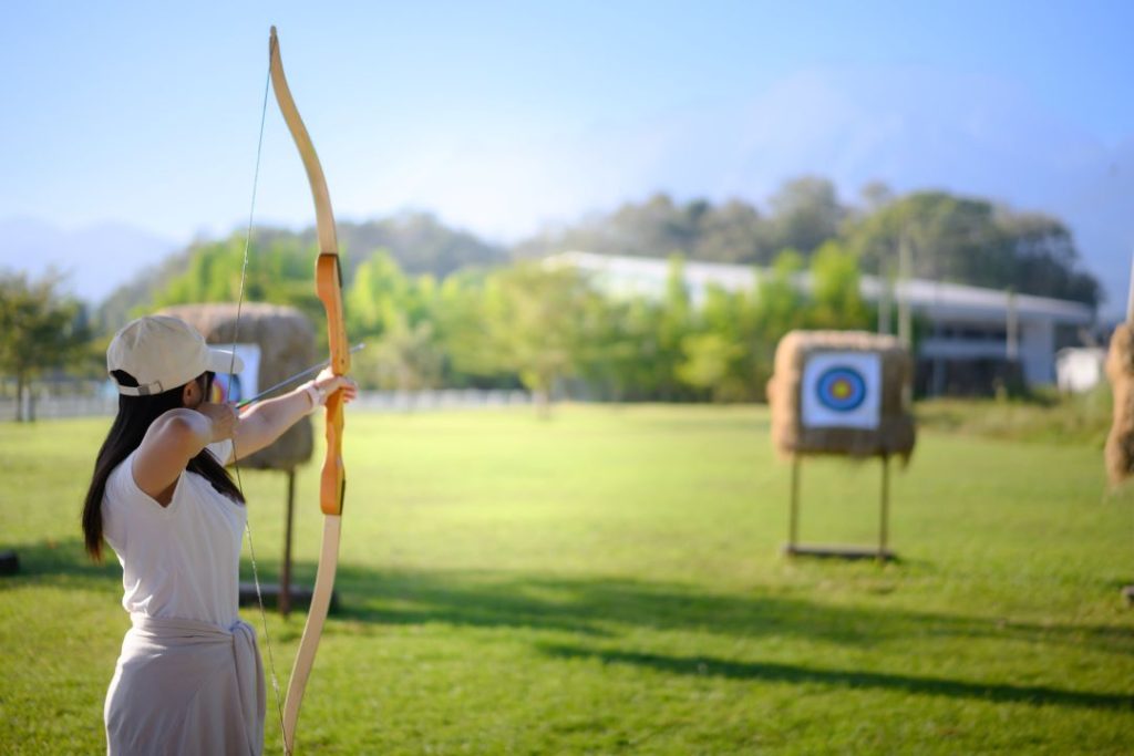 hen weekend, a person practicing archery at straw targets outdoors