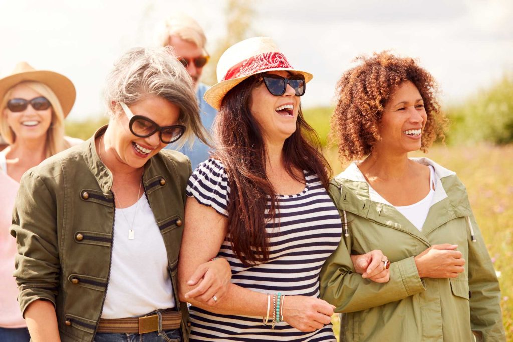 international women's day ideas for companies, A group of women walking along a campsite.
