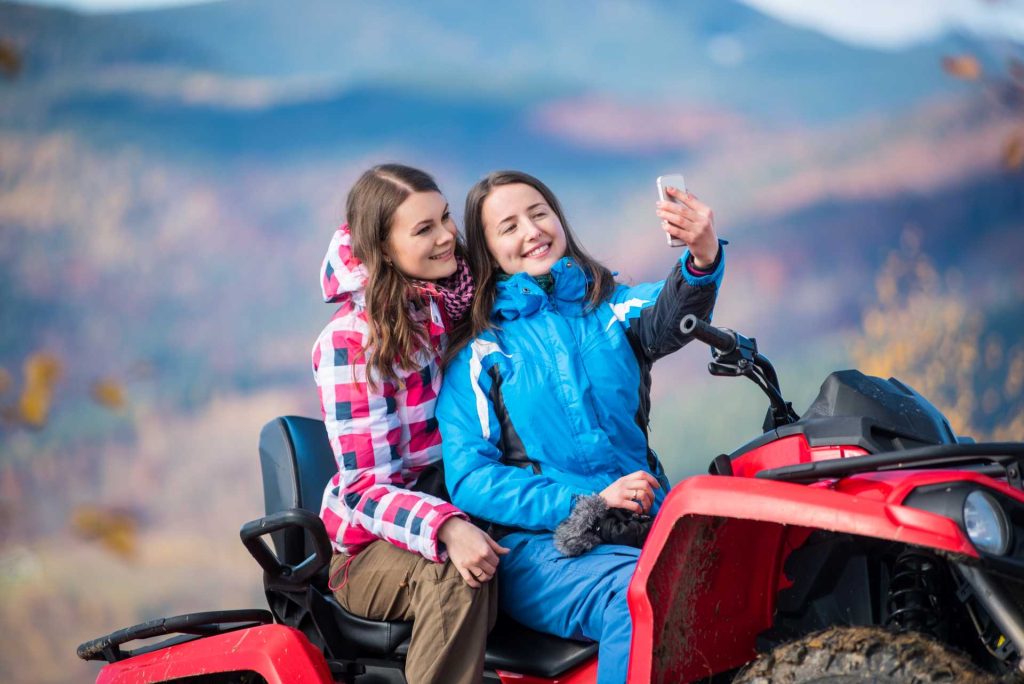 women’s day idea for corporate, Two women riding an ATV clicking a selfie