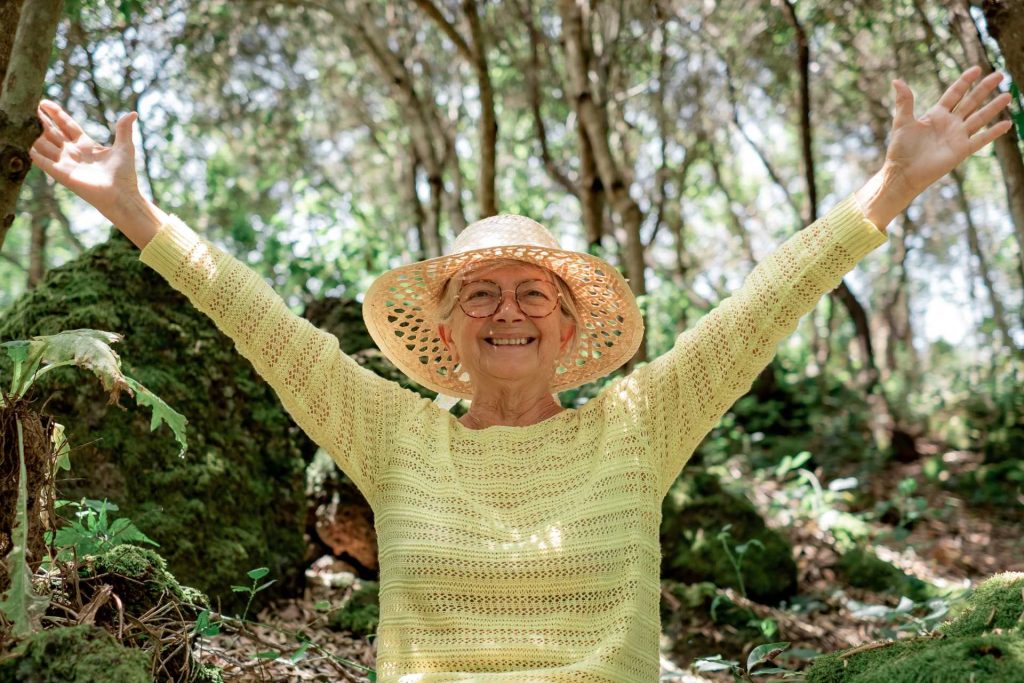 Mother's Day activity, A happy, smiling older woman enjoying the woods.