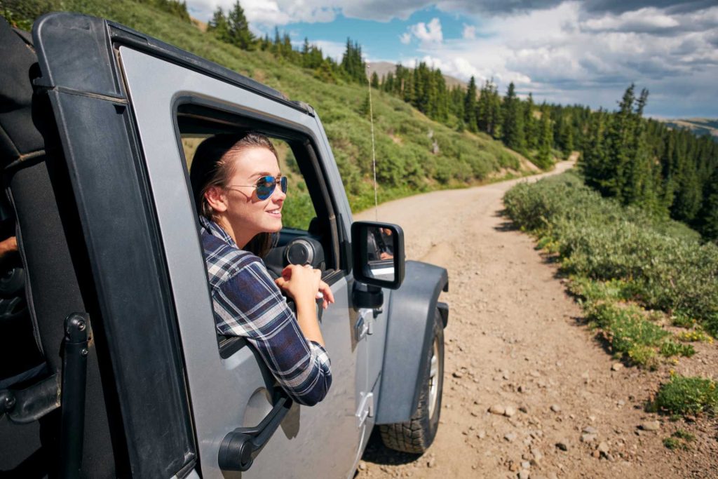 last-minute driving experience, a young woman looks out of an off-road vehicle.
