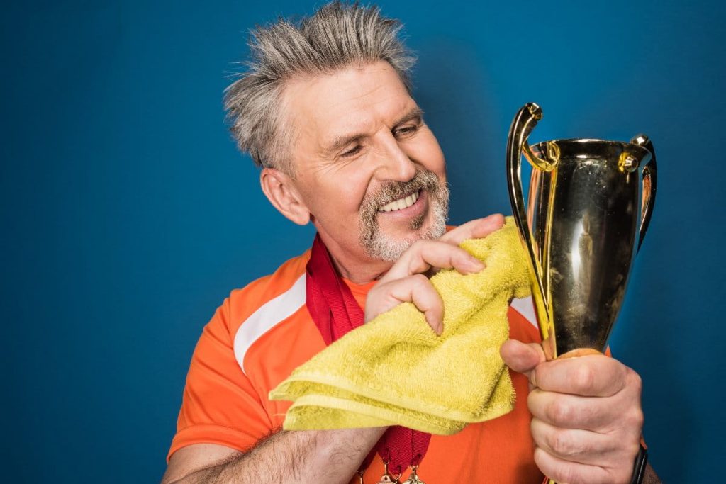 competitive dad polishing his trophy after fathers day activity tournament