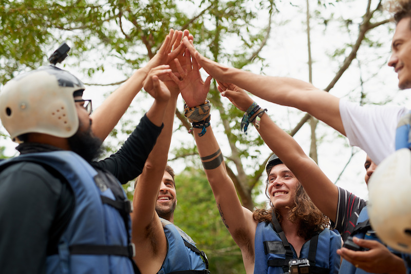 Building employee connections in hybrid teams, team of people putting hands together.